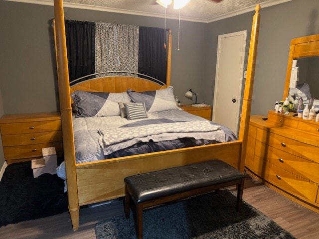 bedroom featuring crown molding, wood-type flooring, and a textured ceiling