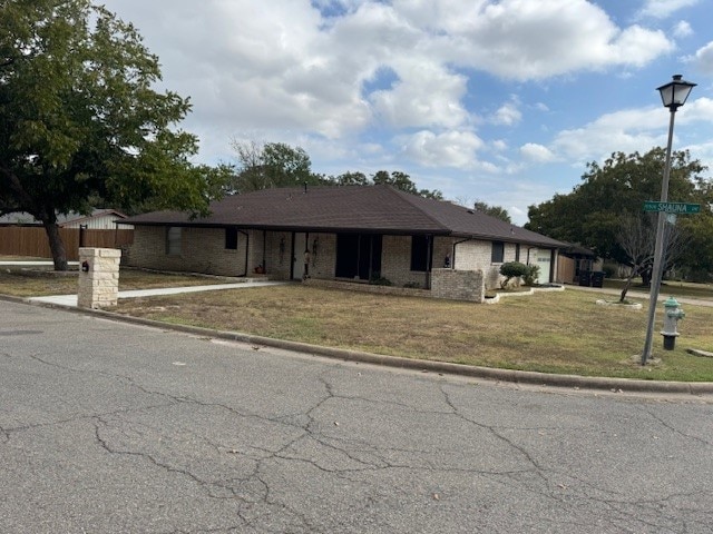 ranch-style house featuring a front yard