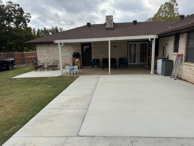 back of property featuring french doors, a patio area, and a yard