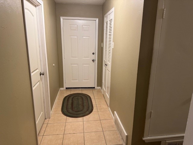 doorway to outside with light tile patterned floors