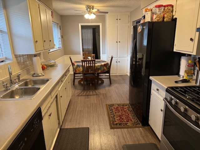 kitchen featuring black appliances, sink, a textured ceiling, light hardwood / wood-style floors, and white cabinets