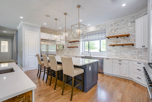 kitchen with white cabinets, a center island, a breakfast bar area, and light wood-type flooring