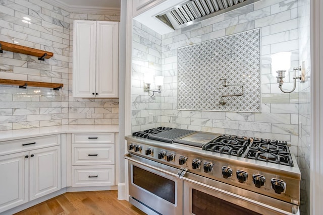 kitchen featuring ornamental molding, white cabinetry, double oven range, and light wood-type flooring