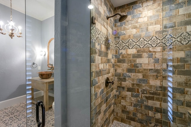 bathroom with sink, a chandelier, a tile shower, and tile patterned floors