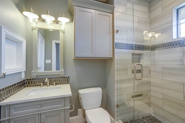 bathroom featuring vanity, a shower with shower door, and toilet