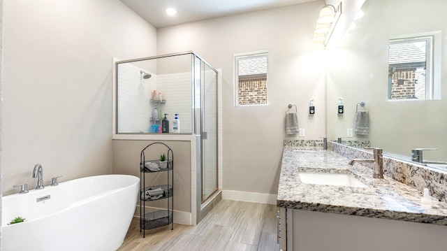 bathroom featuring double vanity, plus walk in shower, and a wealth of natural light