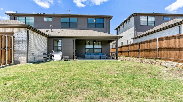 rear view of property featuring ceiling fan, a patio area, outdoor lounge area, and a yard