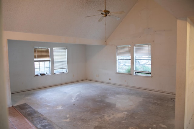 unfurnished room with ceiling fan and high vaulted ceiling