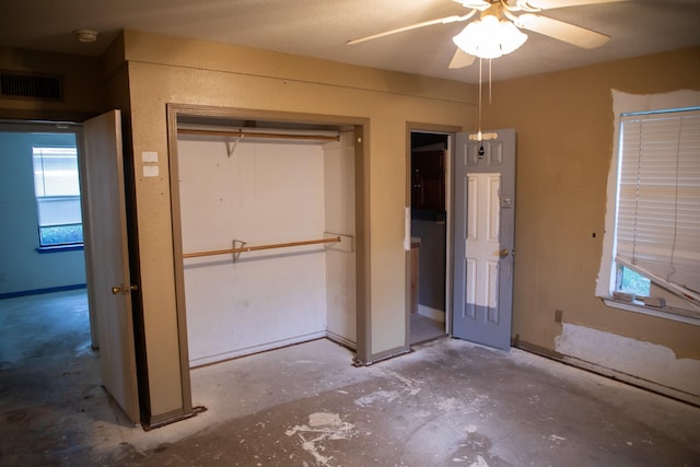 unfurnished bedroom featuring ceiling fan, concrete flooring, and a closet