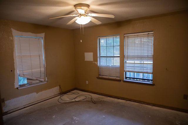 unfurnished room with ceiling fan and concrete floors