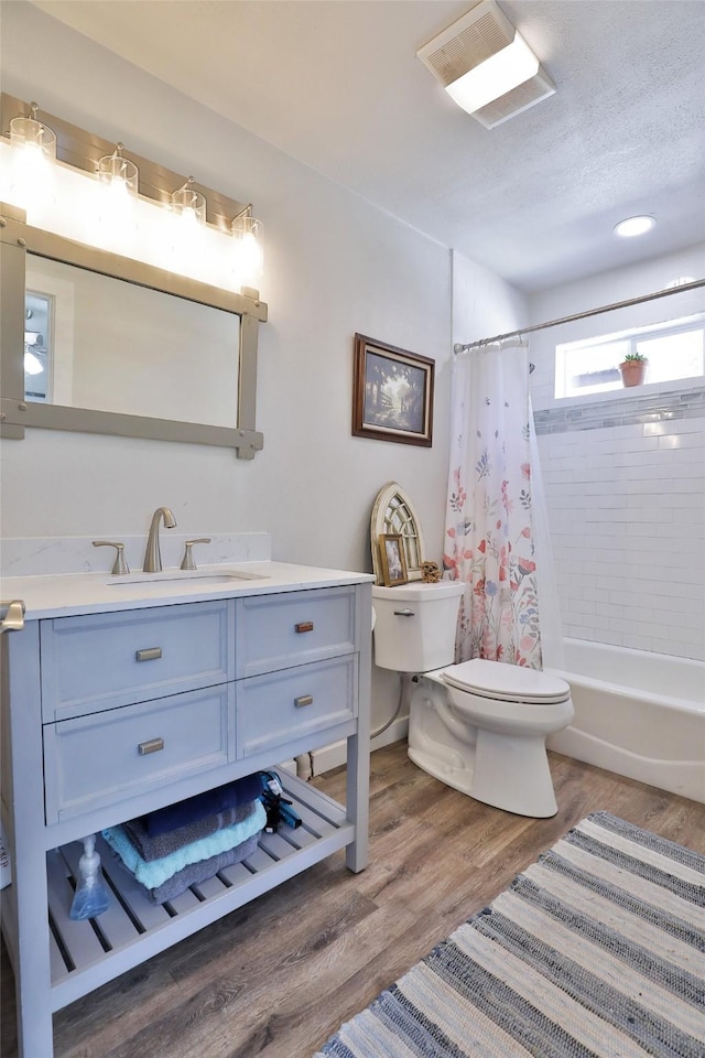 full bathroom featuring visible vents, toilet, wood finished floors, vanity, and shower / bathtub combination with curtain