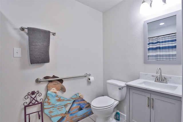 bathroom featuring vanity, tile patterned flooring, and toilet