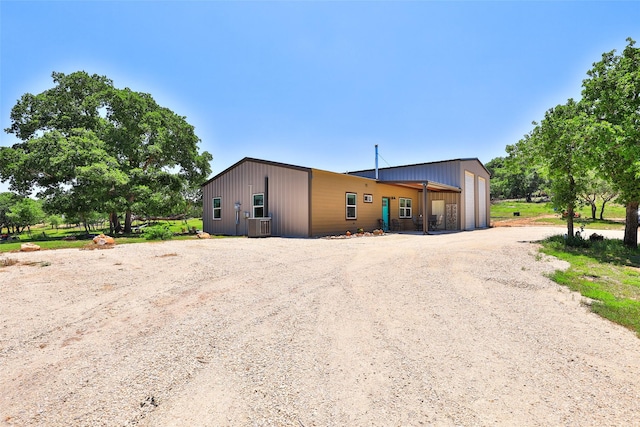 exterior space featuring central air condition unit, driveway, and a garage