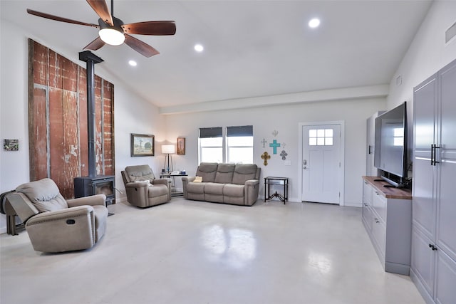 living room with a wood stove, vaulted ceiling, and ceiling fan