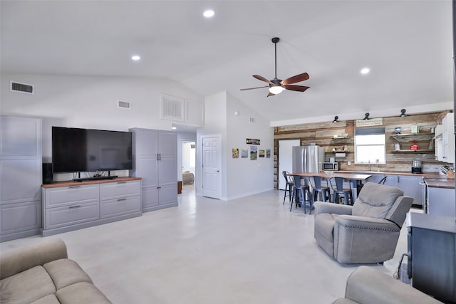 living room featuring ceiling fan and vaulted ceiling