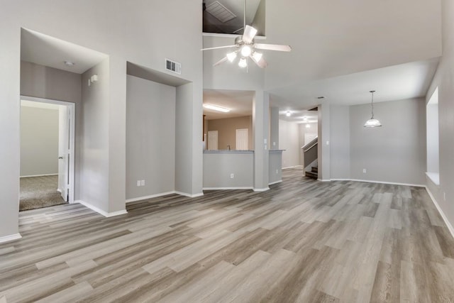 unfurnished living room featuring light hardwood / wood-style floors, high vaulted ceiling, and ceiling fan