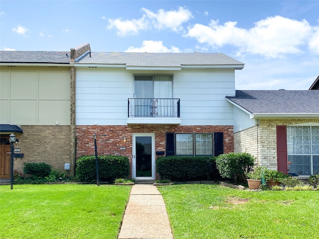 view of front of property featuring a balcony and a front lawn