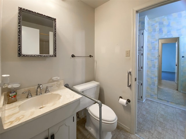 bathroom featuring baseboards, vanity, and toilet