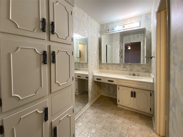 bathroom with wallpapered walls, backsplash, and vanity