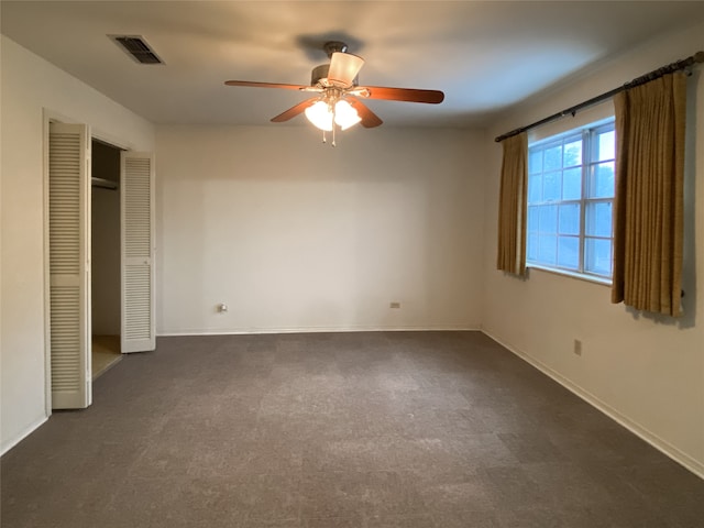 unfurnished bedroom featuring dark colored carpet and ceiling fan