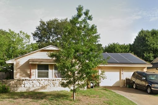 view of front of property with a garage and solar panels