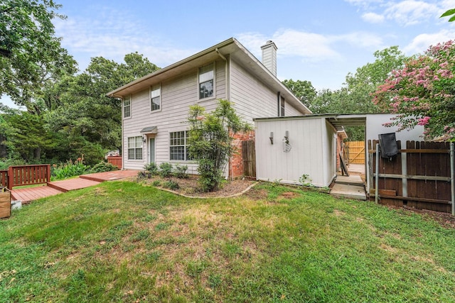 rear view of house featuring a storage unit, a deck, and a lawn