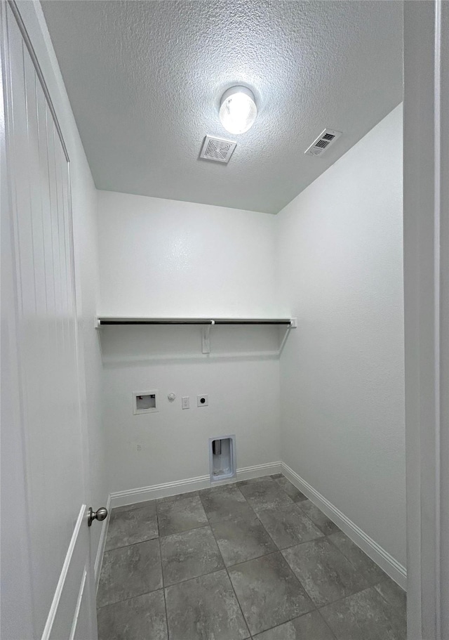 clothes washing area with hookup for an electric dryer, hookup for a gas dryer, a textured ceiling, and hookup for a washing machine