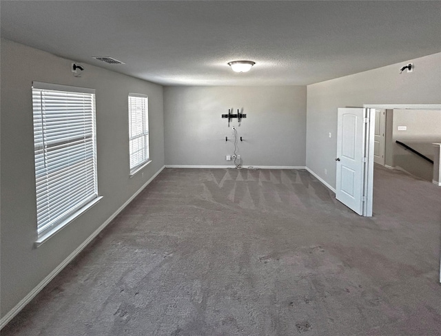 carpeted spare room with a textured ceiling