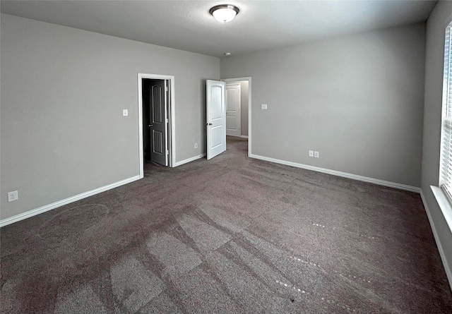 unfurnished bedroom with dark colored carpet