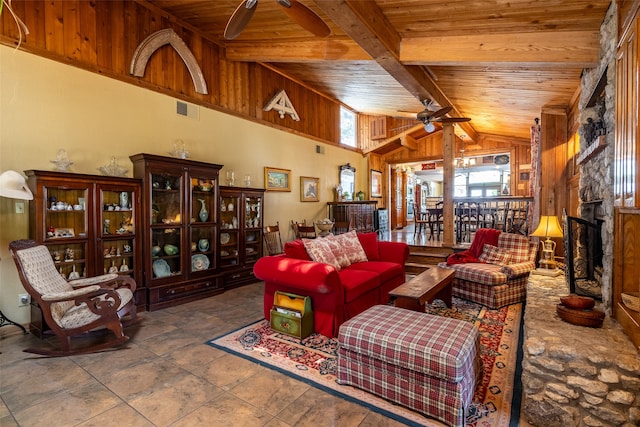 living room featuring a fireplace, wooden ceiling, beamed ceiling, wood walls, and ceiling fan