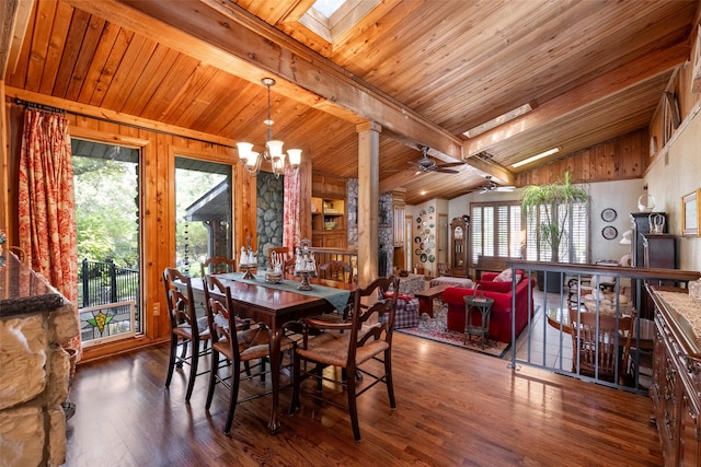 dining space with ceiling fan with notable chandelier, a wealth of natural light, lofted ceiling with skylight, and dark hardwood / wood-style floors