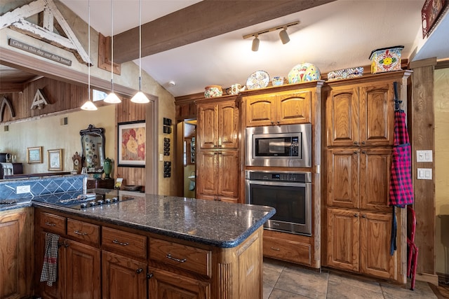 kitchen with dark stone countertops, vaulted ceiling, stainless steel appliances, and hanging light fixtures