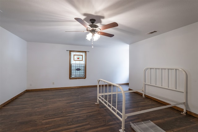 empty room with ceiling fan and dark hardwood / wood-style floors