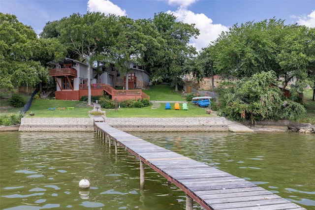 view of dock featuring a yard and a deck with water view