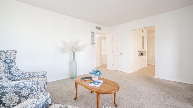 living area featuring light carpet