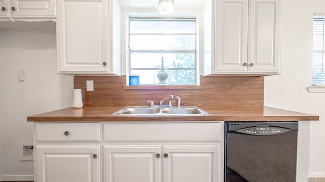 kitchen with white cabinets, wooden counters, sink, and black dishwasher