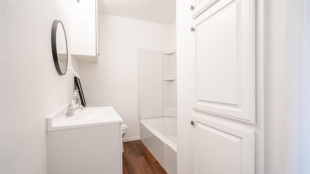 full bathroom with wood-type flooring, shower / washtub combination, vanity, and toilet