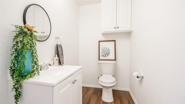 bathroom with vanity, wood-type flooring, and toilet