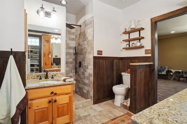 bathroom with tile patterned floors, toilet, vanity, and a tile shower