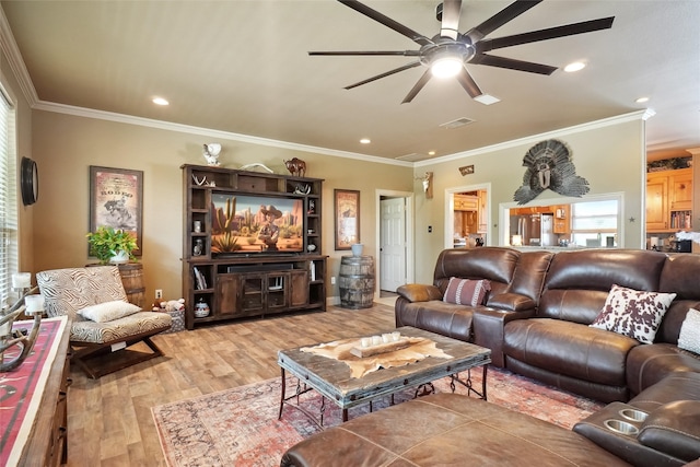 living room with ornamental molding, hardwood / wood-style flooring, and ceiling fan