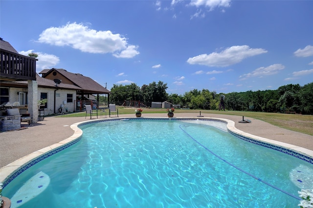 view of swimming pool featuring a patio area and a lawn