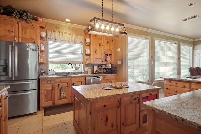 kitchen with backsplash, a center island, hanging light fixtures, appliances with stainless steel finishes, and sink