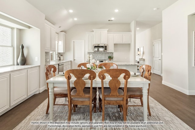 dining space with lofted ceiling, sink, and dark wood-type flooring