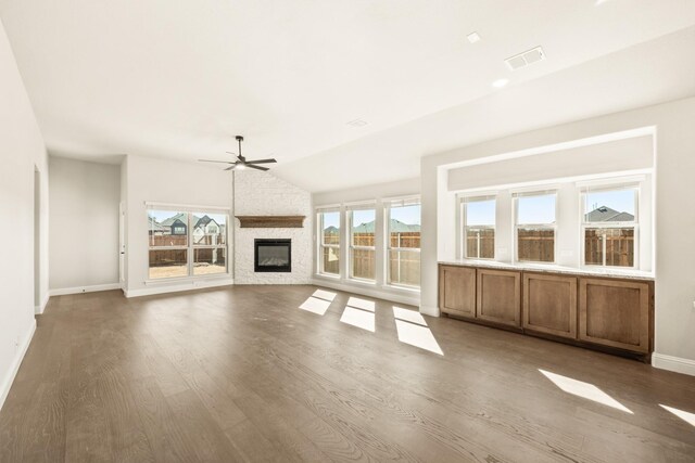 living room featuring lofted ceiling, dark wood-type flooring, a wealth of natural light, and ceiling fan