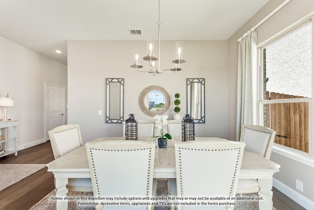 dining area featuring dark hardwood / wood-style floors and a chandelier