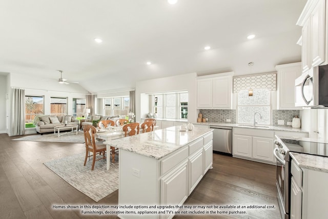 kitchen with sink, white cabinetry, appliances with stainless steel finishes, plenty of natural light, and a kitchen island