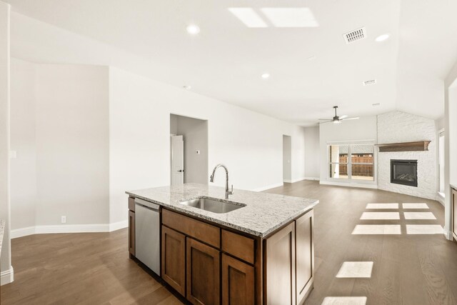 kitchen with sink, white cabinetry, hardwood / wood-style floors, stainless steel appliances, and light stone countertops