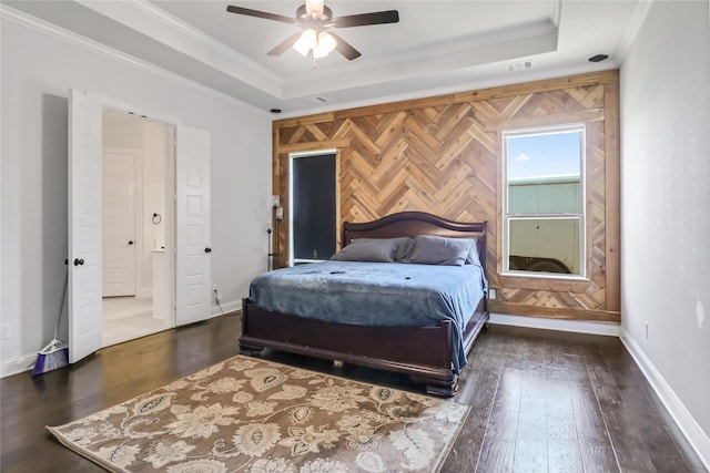 bedroom with dark hardwood / wood-style flooring, a raised ceiling, ceiling fan, and ornamental molding