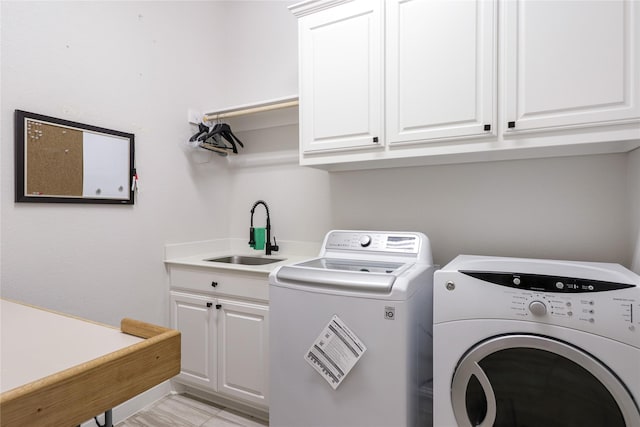 washroom with cabinets, separate washer and dryer, and sink