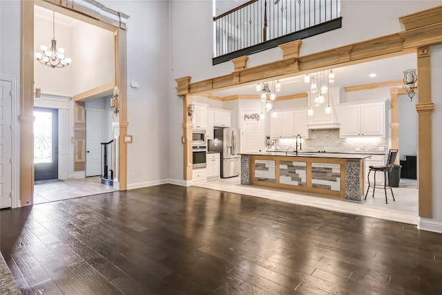 living room with a chandelier, a high ceiling, hardwood / wood-style flooring, and sink